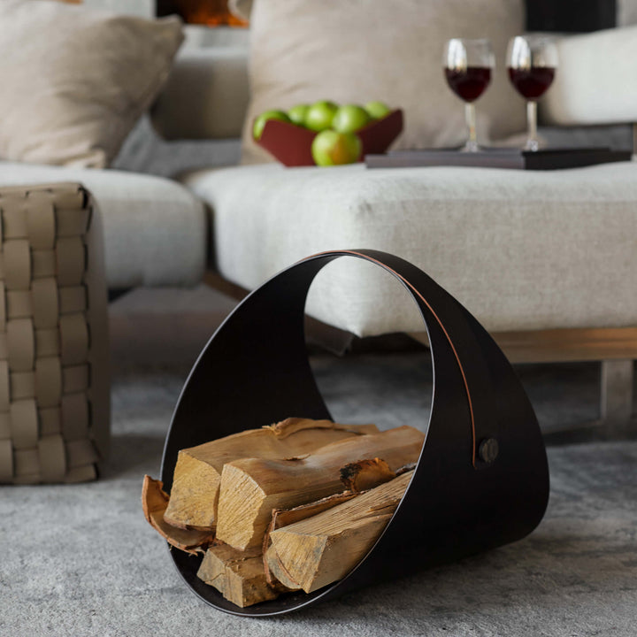 Black leather firewood holder with logs in a living room setting