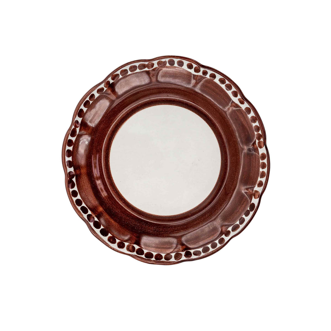 Brown ceramic plate with decorative rim on a white background