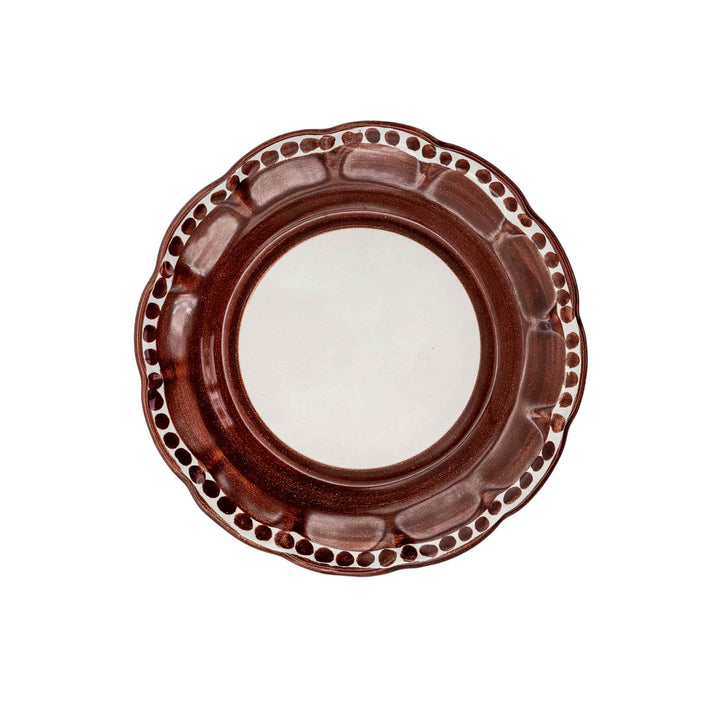 Brown ceramic plate with decorative rim on a white background
