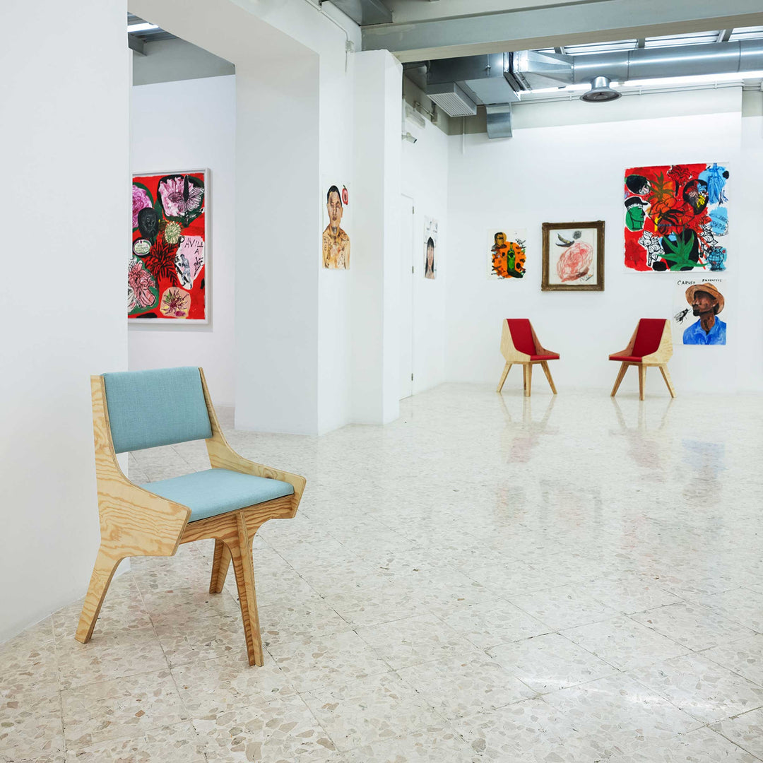 Falcone Blue chair by Jules Regis, phenolic CLT structure with blue fabric upholstery, contemporary designer seating in an art gallery